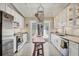 Galley kitchen featuring bright white cabinets, granite countertops, and stainless steel appliances at 20 Spaniards Rd, Placida, FL 33946