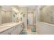 Bright bathroom with double sink vanity, tiled walk-in shower, neutral decor, and decorative elements at 2117 Laurifolia Ct, North Port, FL 34289