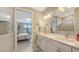Bright bathroom showcasing dual sinks, a framed mirror, a tiled walk-in shower, and stylish decor at 2117 Laurifolia Ct, North Port, FL 34289