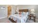 Cozy bedroom with a wood-frame bed, neutral walls, coordinated decor and a glimpse into an en-suite bathroom at 2117 Laurifolia Ct, North Port, FL 34289