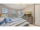 Cozy bedroom featuring a large bed, wood dresser, TV, and three windows with views of the exterior at 2117 Laurifolia Ct, North Port, FL 34289