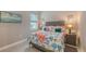 Relaxing bedroom featuring coral and nautical decor, a queen-sized bed, and natural lighting at 2117 Laurifolia Ct, North Port, FL 34289
