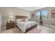A neutral tone bedroom features a plush bed with coordinated decor, a window with blinds, and stylish furnishings at 2117 Laurifolia Ct, North Port, FL 34289
