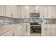 A modern kitchen featuring sleek stainless steel appliances, stylish backsplash and ample cabinet space at 2117 Laurifolia Ct, North Port, FL 34289