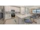 Modern kitchen features stainless appliances, tile backsplash, island with counter seating and an adjacent dining area at 2117 Laurifolia Ct, North Port, FL 34289