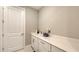 Well-lit laundry room with a utility sink, ample counter space, and storage cabinets at 2117 Laurifolia Ct, North Port, FL 34289