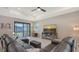 Cozy living room featuring a comfortable leather sofa and sliding glass doors to the backyard at 2117 Laurifolia Ct, North Port, FL 34289