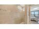 Bright shower with custom tiled walls, glass partition, and a glimpse into the bedroom at 2117 Laurifolia Ct, North Port, FL 34289