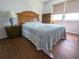 Comfortable bedroom with wood flooring, a blue and white bedspread and a nightstand at 25100 Sandhill Blvd # T101, Punta Gorda, FL 33983
