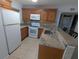 Well-equipped kitchen with granite countertops, wooden cabinetry, and modern white appliances at 25100 Sandhill Blvd # T101, Punta Gorda, FL 33983