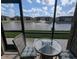 Enclosed patio featuring stylish tile flooring and a cozy seating area overlooking the water and fountain at 25100 Sandhill Blvd # T101, Punta Gorda, FL 33983