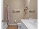 Cozy bathroom with neutral walls, framed coastal artwork, and a white vanity with a framed mirror at 2669 Wax Myrtle Ct, Port Charlotte, FL 33953