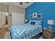 Charming bedroom with a vibrant blue accent wall, coastal decorations, and comfortable furnishings at 2669 Wax Myrtle Ct, Port Charlotte, FL 33953