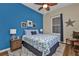 Comfortable bedroom featuring a blue accent wall, nautical decor, and warm, inviting lighting at 2669 Wax Myrtle Ct, Port Charlotte, FL 33953