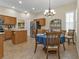 Bright dining area featuring tile floors, modern chandelier, and stainless appliances at 2669 Wax Myrtle Ct, Port Charlotte, FL 33953