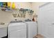 Bright laundry room with modern appliances, storage shelves, and a utility sink at 2669 Wax Myrtle Ct, Port Charlotte, FL 33953