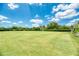 Expansive manicured lawn with mature trees and shrubs and shaded bench seating at 2669 Wax Myrtle Ct, Port Charlotte, FL 33953