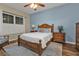 Well-lit main bedroom showcasing hardwood floors and wooden furniture at 2669 Wax Myrtle Ct, Port Charlotte, FL 33953