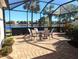 Enjoy serene lake views from this screened lanai with its ample seating, brick floor, and lush landscaping at 2669 Wax Myrtle Ct, Port Charlotte, FL 33953