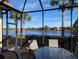 Inviting screened lanai featuring a glass-topped table and chairs with a stunning view of the adjacent lake at 2669 Wax Myrtle Ct, Port Charlotte, FL 33953