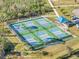Aerial view of community pickleball courts with shade canopy and seating at 2669 Wax Myrtle Ct, Port Charlotte, FL 33953