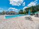 Community pool featuring tanning deck, lounge chairs, and multiple umbrellas at 2669 Wax Myrtle Ct, Port Charlotte, FL 33953