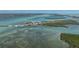 Stunning aerial view of waterfront condos with boat docks, surrounded by turquoise waters and lush greenery at 2769 N Beach Rd # 105, Englewood, FL 34223