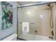 Bathtub with glass door featuring mounted shower head and seaside-themed accents at 2769 N Beach Rd # 105, Englewood, FL 34223