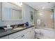 Bright bathroom featuring a large vanity and a combination tub and shower at 2769 N Beach Rd # 105, Englewood, FL 34223