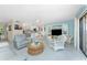 Bright, open living room with tile floors, comfortable seating, and access to the kitchen and screened lanai at 2769 N Beach Rd # 105, Englewood, FL 34223
