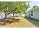 A spacious backyard with mature trees, a storage shed, and a white privacy fence at 2821 Embassy Rd, North Port, FL 34291