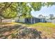 Expansive backyard featuring a screen enclosed patio, white privacy fence, and mature shade trees at 2821 Embassy Rd, North Port, FL 34291