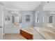 Bathroom with double sinks, tub, and a window for natural light at 2821 Embassy Rd, North Port, FL 34291