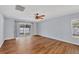 Open living room with wood floors, ceiling fan and sliding glass doors to the patio at 2821 Embassy Rd, North Port, FL 34291