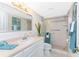 Bright bathroom featuring a white vanity, a decorative mirror, and a glass-enclosed shower at 2955 N Beach Rd # D113, Englewood, FL 34223