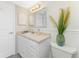 Classic bathroom with white cabinets, a decorative mirror and coastal decor at 2955 N Beach Rd # D113, Englewood, FL 34223