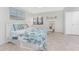 Serene bedroom featuring a white bed frame, tiled floor, coastal accents, and sunlit windows at 2955 N Beach Rd # D113, Englewood, FL 34223