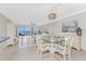 Dining area with a glass-top table set for four, offers serene water views, adjacent to the living area at 2955 N Beach Rd # D113, Englewood, FL 34223