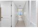 Hallway featuring white doors, tile flooring, and a glimpse of the water at 2955 N Beach Rd # D113, Englewood, FL 34223