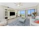Comfortable living room with coastal decor, patio access, stunning water views, and a ceiling fan at 2955 N Beach Rd # D113, Englewood, FL 34223