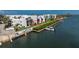 View of the waterfront condos with boat docks on a sunny day, surrounded by lush landscaping in a gated community at 2955 N Beach Rd # D113, Englewood, FL 34223
