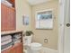 Bright bathroom features tile flooring, a window, cabinet with linens, and toilet at 30 Buccaneer Bnd, Placida, FL 33946
