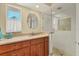 Bright bathroom featuring a glass shower, granite countertop, sink, vanity, and round mirror at 30 Buccaneer Bnd, Placida, FL 33946