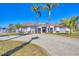 Inviting home with mature palm trees, gravel driveway, and a well-manicured lawn at 30 Buccaneer Bnd, Placida, FL 33946