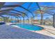 Beautiful in-ground pool inside of screened lanai, surrounded by palm trees and landscaping at 30 Buccaneer Bnd, Placida, FL 33946