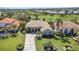 Aerial view of a home with manicured lawn and a paver driveway, surrounded by lush landscaping at 3511 Bay Ridge Way, Port Charlotte, FL 33953