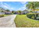 Charming single-story home featuring a well-manicured lawn and tropical landscaping with palm trees along the patterned driveway at 3511 Bay Ridge Way, Port Charlotte, FL 33953