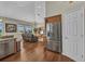Open-concept living room with stainless refrigerator, view of entertaining area, and lots of natural light at 3511 Bay Ridge Way, Port Charlotte, FL 33953