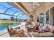 Relax on this screened-in patio with comfortable seating, a cozy fire pit, and views of the private pool and yard at 3511 Bay Ridge Way, Port Charlotte, FL 33953