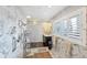 Contemporary bathroom boasts marble walls, a glass shower, and plantation shutters for privacy at 44 Waterford Dr, Englewood, FL 34223